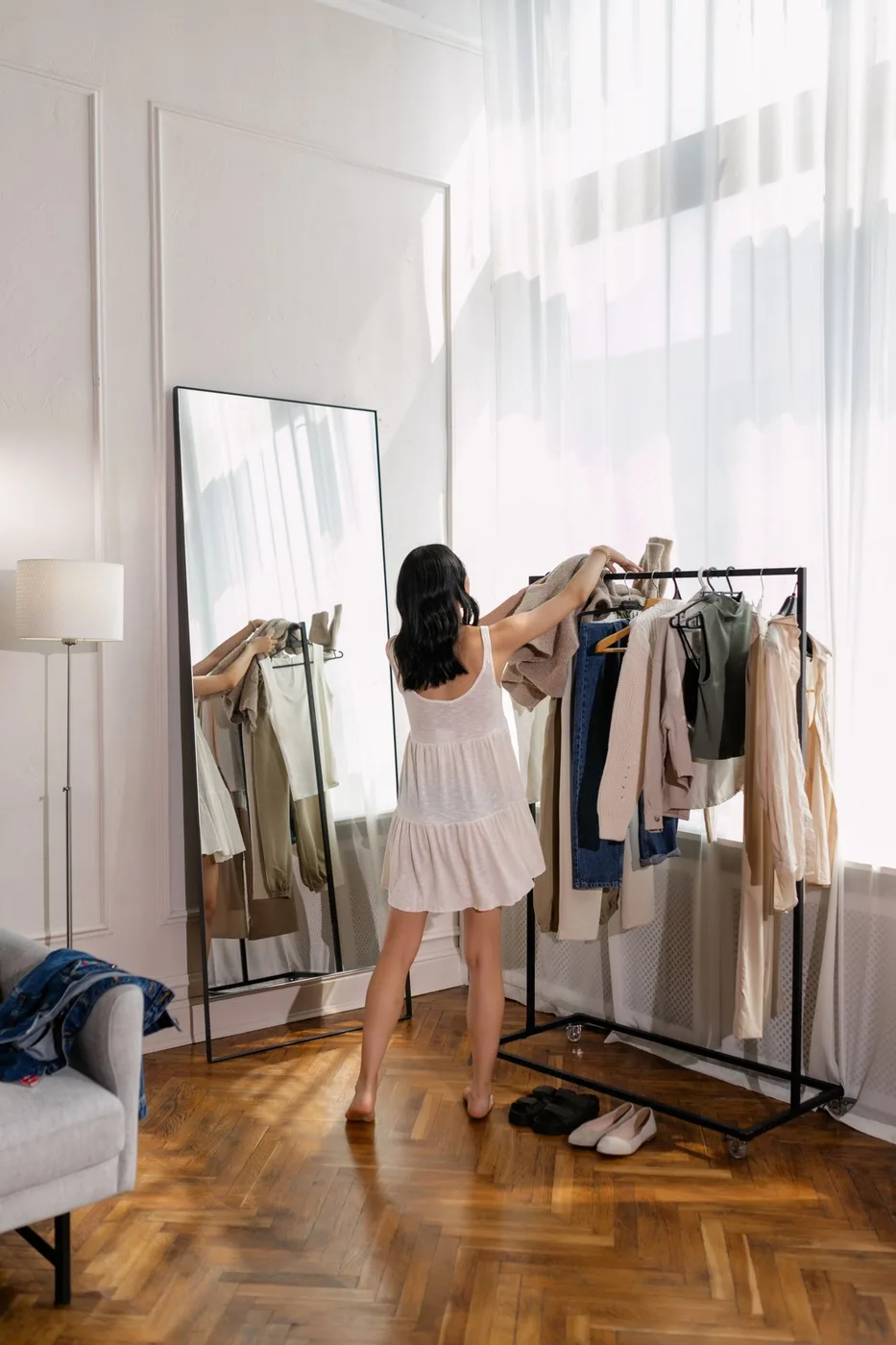 Woman choosing clothing from a bright, open clothes rack