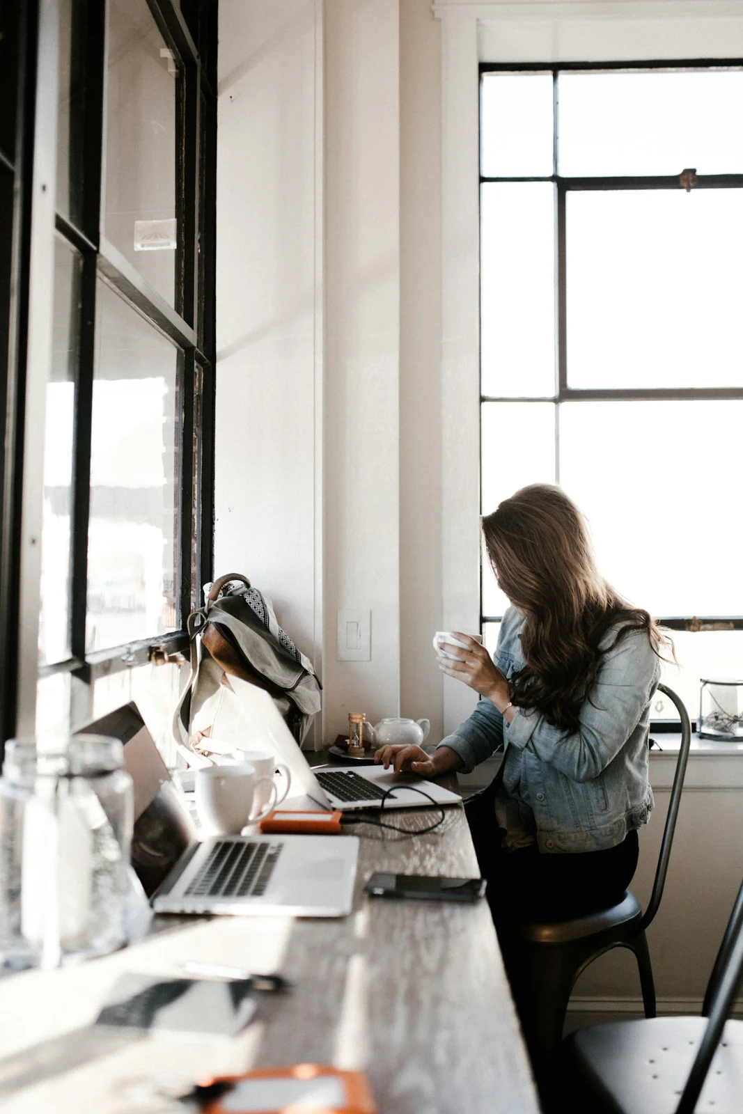 A person wearing a denim jacket while working at a table.