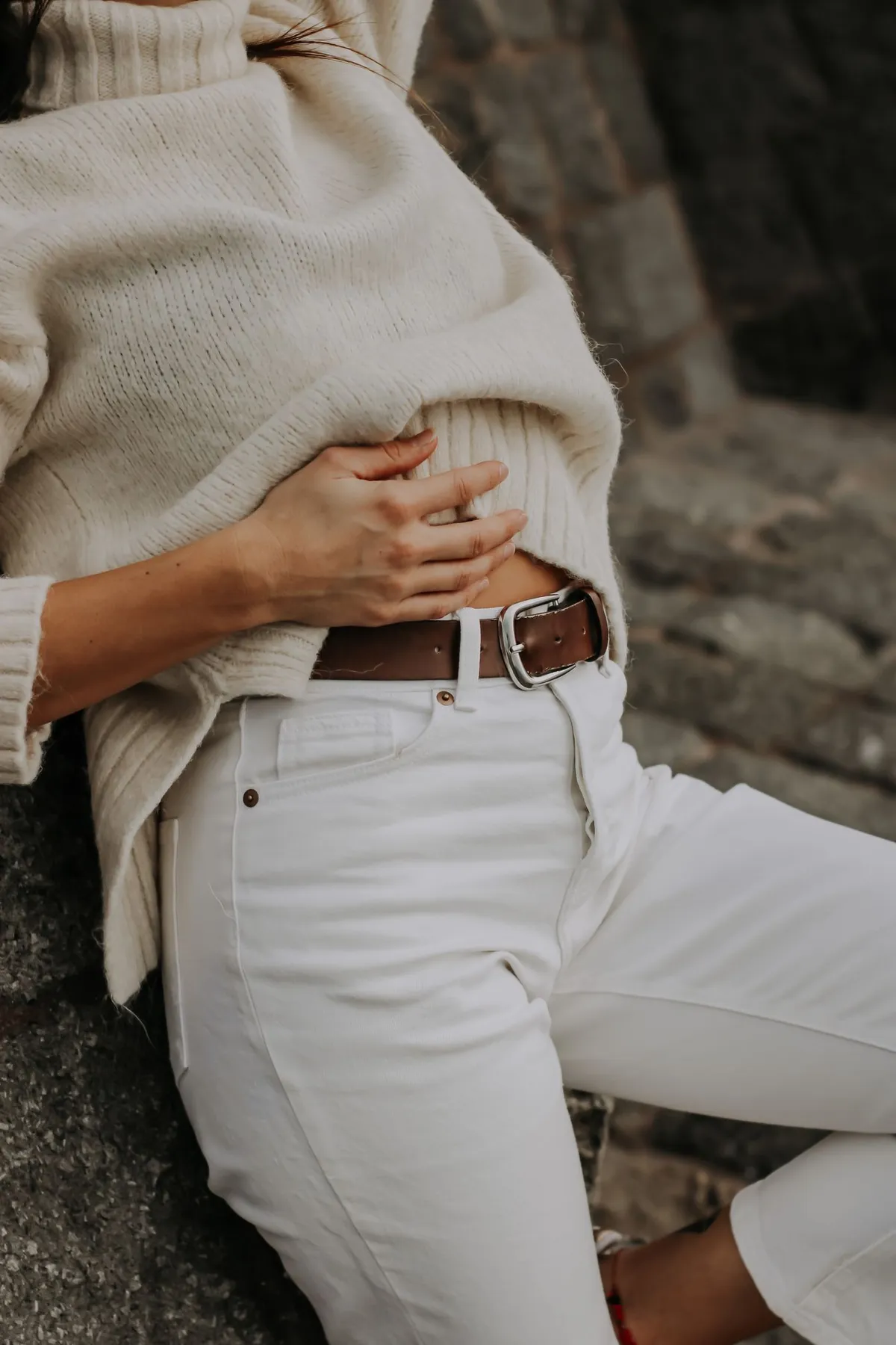 A person wearing pale trousers with a brown belt.